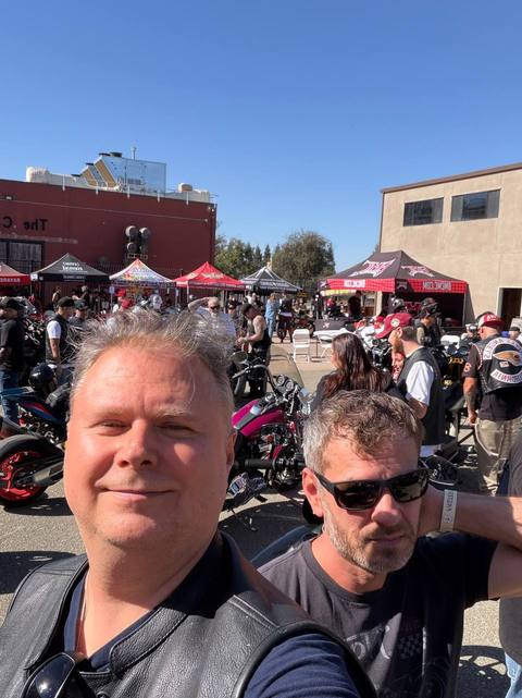 Two people at an outdoor motorcycle gathering.