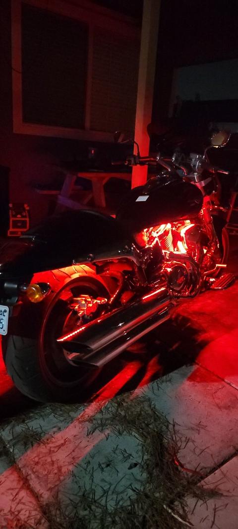 Motorcycles parked beside a building in red evening light.