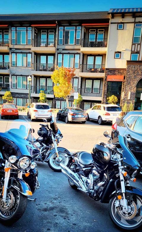 Motorcycles parked in front of a multistory building.