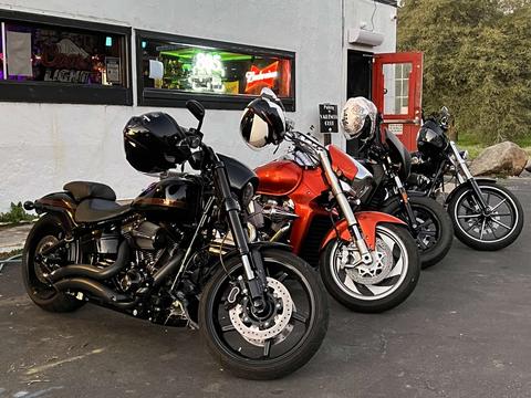 Several motorcycles parked outside a roadside business.