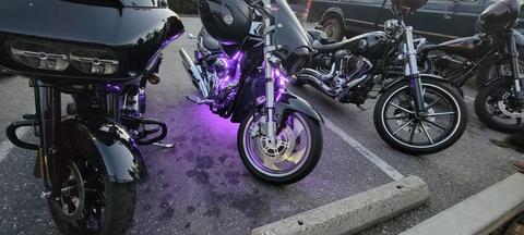 A closer view of motorcycles with purple accent lighting.
