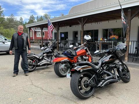 A person standing beside motorcycles at a roadside stop.