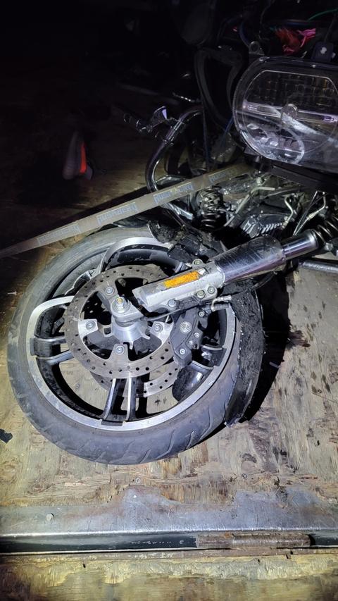 A close view of a motorcycle front wheel at night.