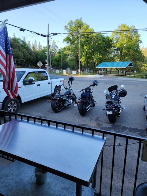 Motorcycles and parked vehicles viewed from a porch.
