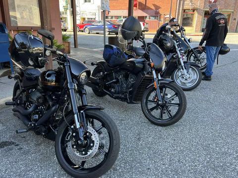 Motorcycles and riders gathered outside a roadside business.