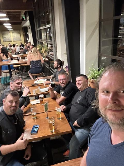Friends seated together around a long restaurant table.