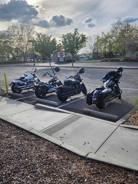 Motorcycles parked outside under cloudy skies.