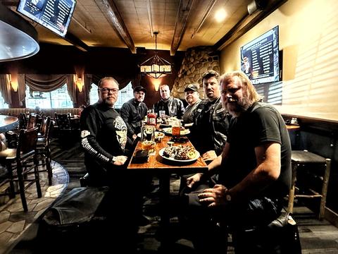 Riders seated together around a restaurant table.