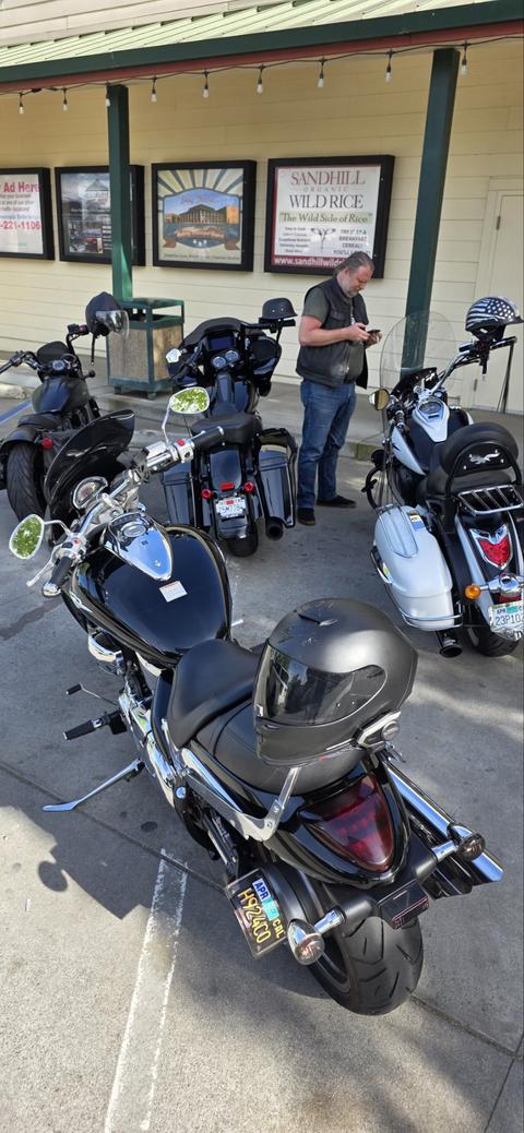 Riders standing near parked motorcycles outside a building.