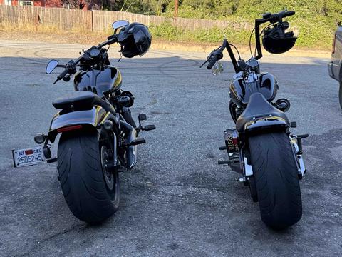A rear view of two motorcycles parked side by side.