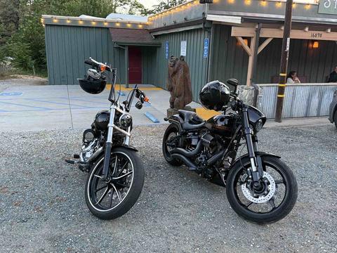 Two motorcycles parked outside a rustic building.